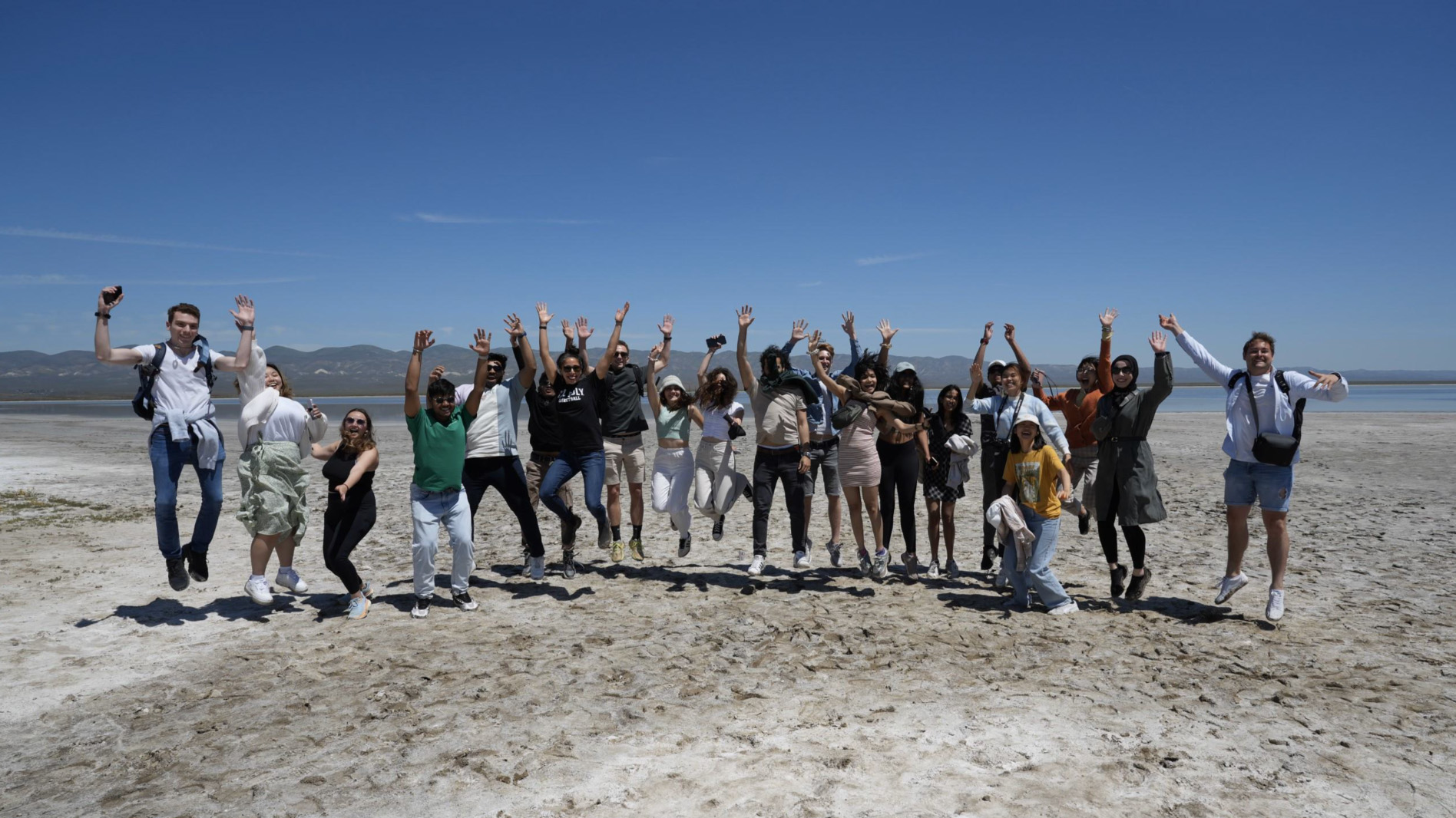 Students jumping in the air on the beach